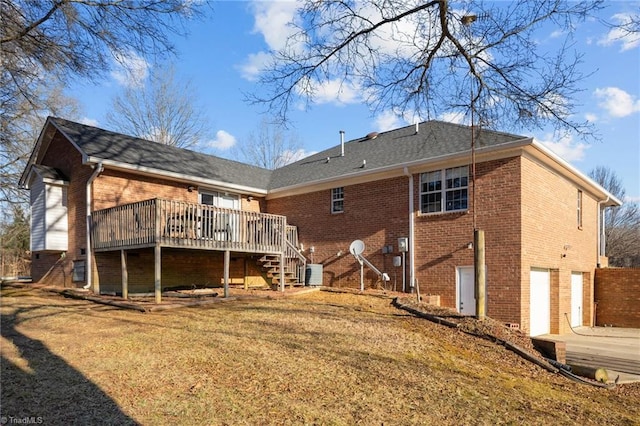 back of property with a lawn, central AC, a wooden deck, and a garage