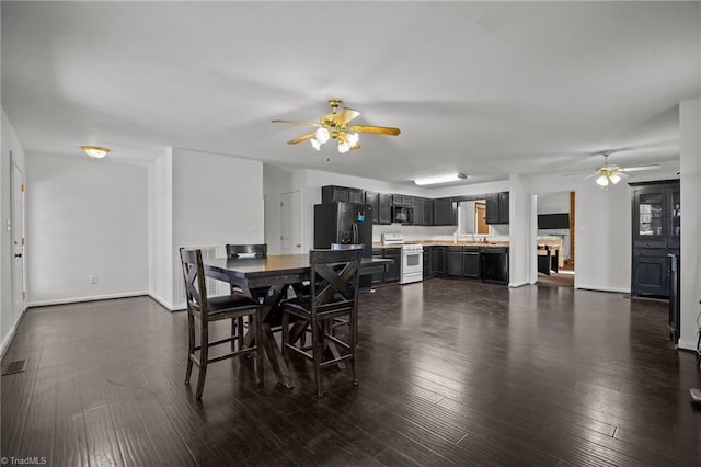 dining area with ceiling fan and dark wood-type flooring