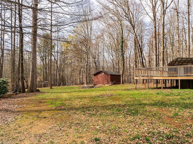 view of yard featuring a wooden deck, an outbuilding, and a storage shed