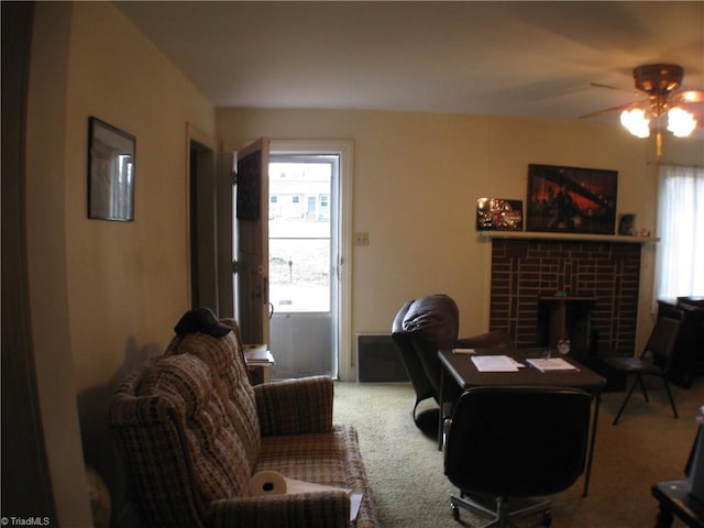 carpeted living area with a fireplace and ceiling fan