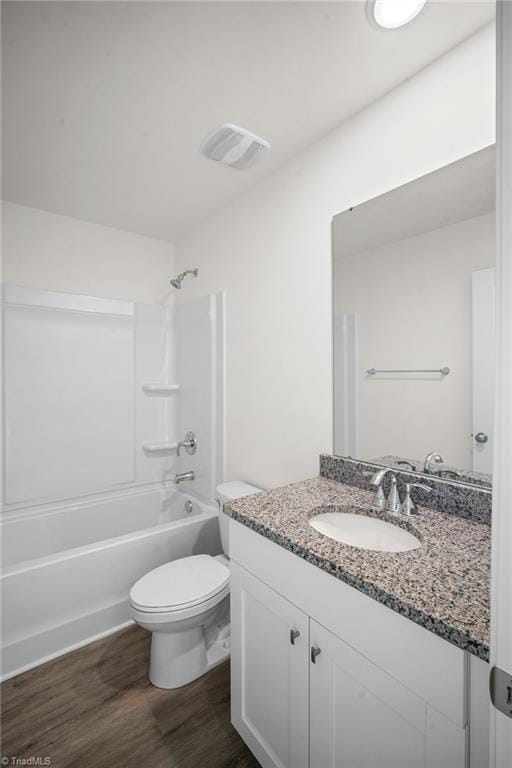 full bathroom featuring vanity, hardwood / wood-style floors, tub / shower combination, and toilet