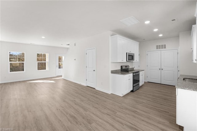 kitchen with stainless steel appliances, light stone countertops, light wood-type flooring, and white cabinets