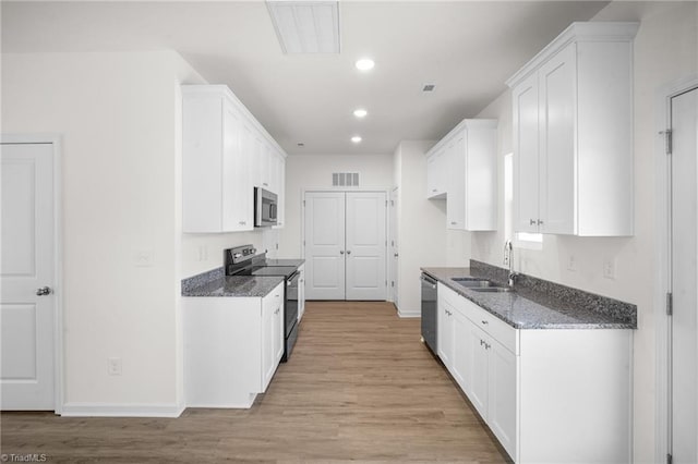 kitchen featuring stainless steel appliances, sink, and white cabinets