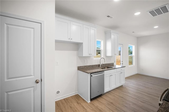 kitchen featuring sink, light hardwood / wood-style flooring, dishwasher, white cabinets, and dark stone counters