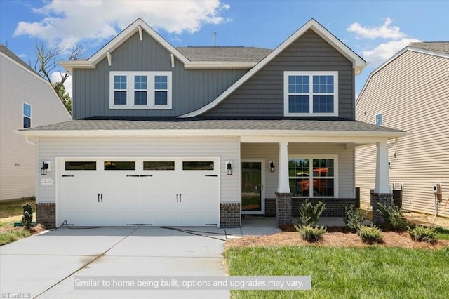 4090 Stallion St Lot 74, High Point, NC 27262 - craftsman-style home with concrete driveway, a porch, brick siding, board and batten siding, and an attached garage
