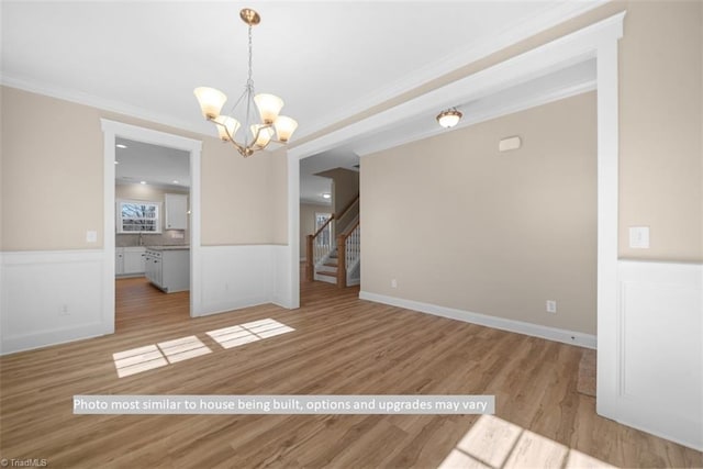 4090 Stallion St Lot 74, High Point, NC 27262 - unfurnished room featuring crown molding, a chandelier, wood finished floors, a wainscoted wall, and stairway