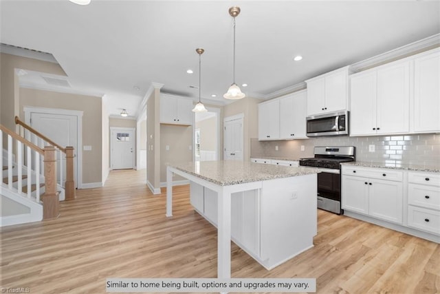4090 Stallion St Lot 74, High Point, NC 27262 - kitchen featuring appliances with stainless steel finishes, backsplash, a kitchen island, white cabinets, and light wood-style floors