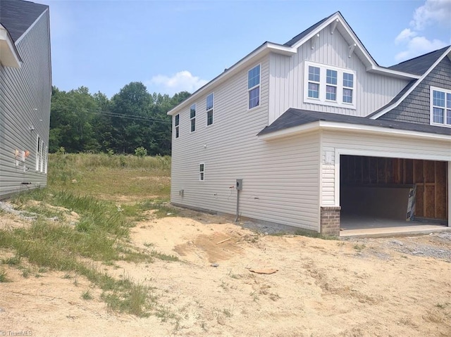 4090 Stallion St Lot 74, High Point, NC 27262 - view of property exterior featuring driveway, board and batten siding, and a garage