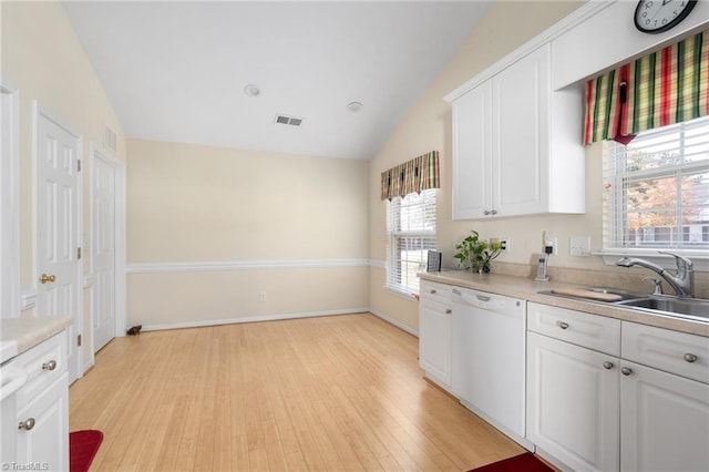 kitchen with lofted ceiling, white cabinetry, sink, and dishwasher