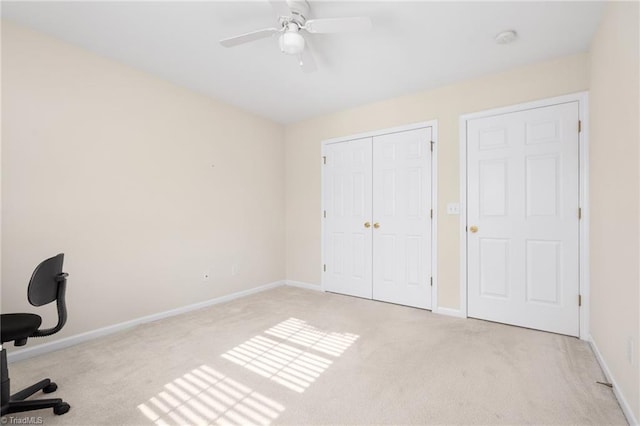 unfurnished office featuring ceiling fan and light carpet