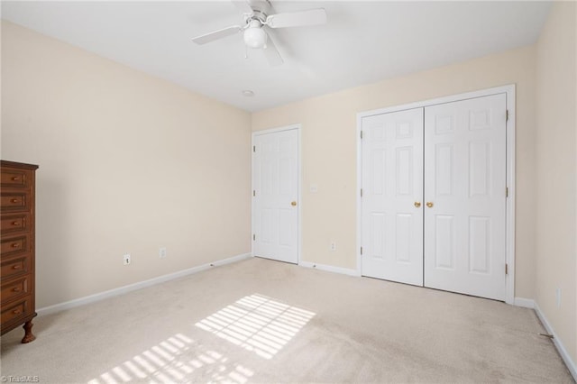 unfurnished bedroom featuring ceiling fan, a closet, and light colored carpet