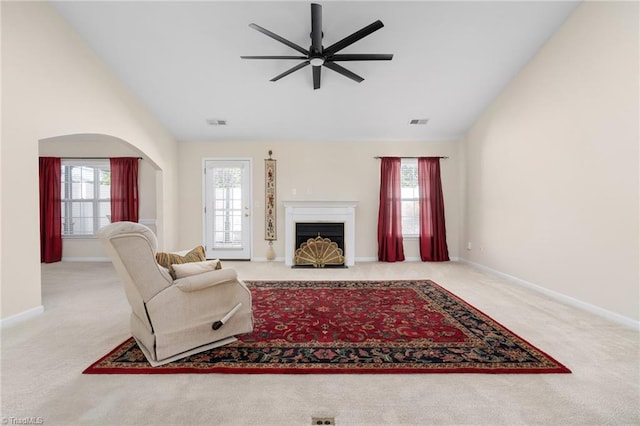 living room with a wealth of natural light, lofted ceiling, light carpet, and ceiling fan