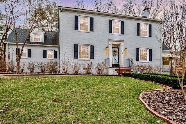 colonial inspired home featuring a lawn