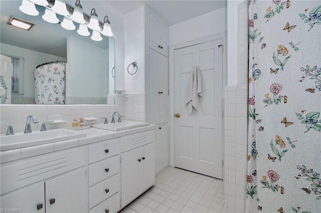 bathroom featuring walk in shower, tile patterned floors, vanity, and backsplash