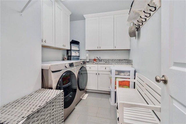 laundry area with cabinets, sink, light tile patterned floors, and washer and clothes dryer