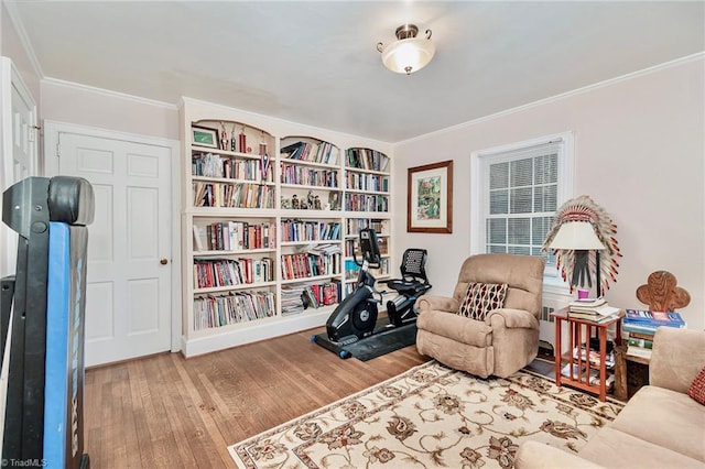 sitting room with hardwood / wood-style floors and ornamental molding