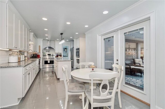 tiled dining space featuring crown molding and french doors