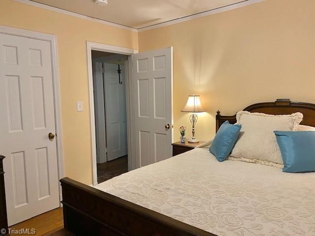 305 W Avondale Dr, Greensboro, NC 27403 - bedroom with ornamental molding and wood finished floors