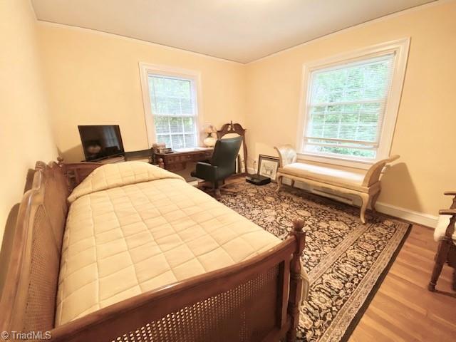 305 W Avondale Dr, Greensboro, NC 27403 - bedroom featuring wood finished floors, baseboards, and ornamental molding
