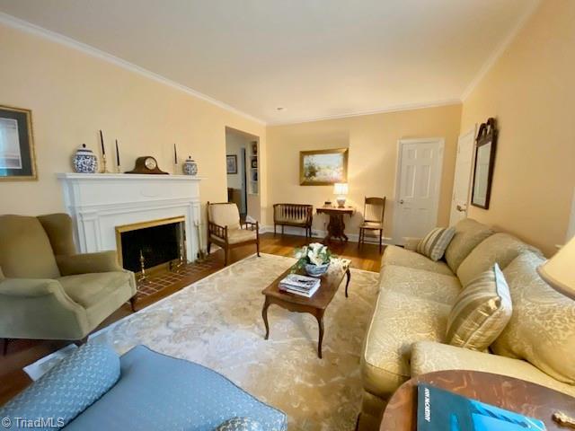 305 W Avondale Dr, Greensboro, NC 27403 - living area with ornamental molding, a fireplace with flush hearth, and wood finished floors
