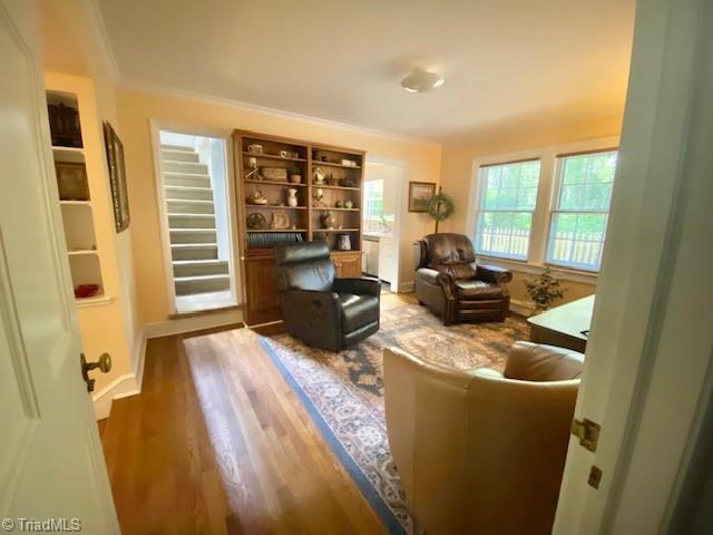 305 W Avondale Dr, Greensboro, NC 27403 - sitting room with wood finished floors, stairs, crown molding, and baseboards