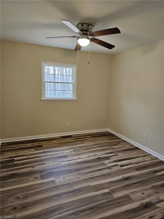 unfurnished room with baseboards and dark wood-style flooring