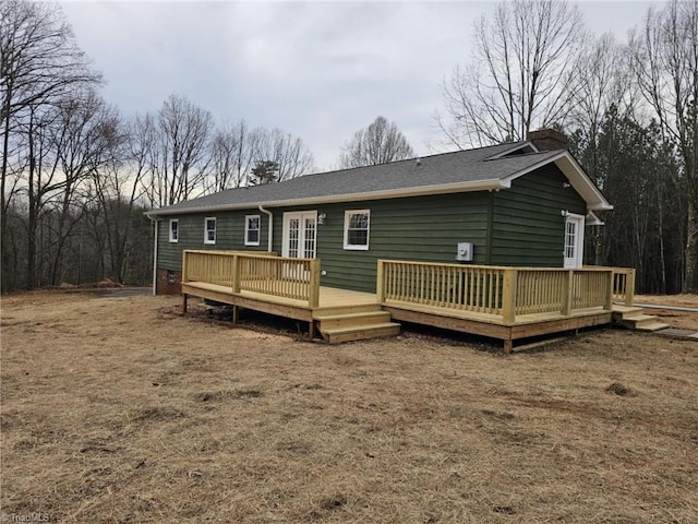 rear view of property featuring a chimney and a deck