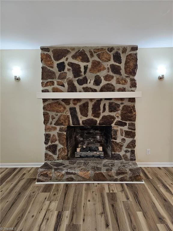 interior details featuring a fireplace, wood finished floors, and baseboards