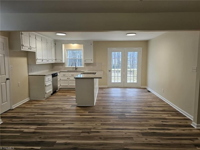 kitchen featuring baseboards, white cabinetry, dark wood finished floors, and stainless steel dishwasher