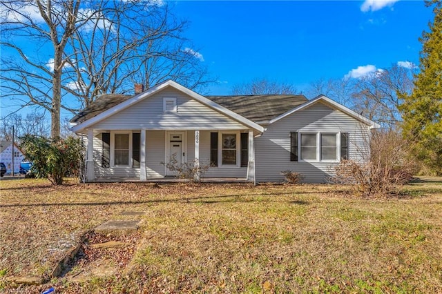 ranch-style home featuring covered porch and a front lawn