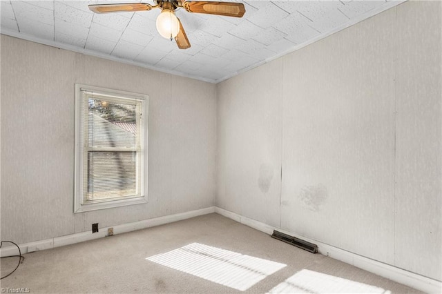 empty room featuring carpet floors, a wealth of natural light, crown molding, and ceiling fan