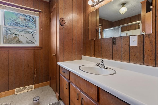 bathroom featuring vanity and wood walls