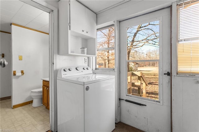 laundry room featuring ornamental molding, cabinets, and washer / dryer