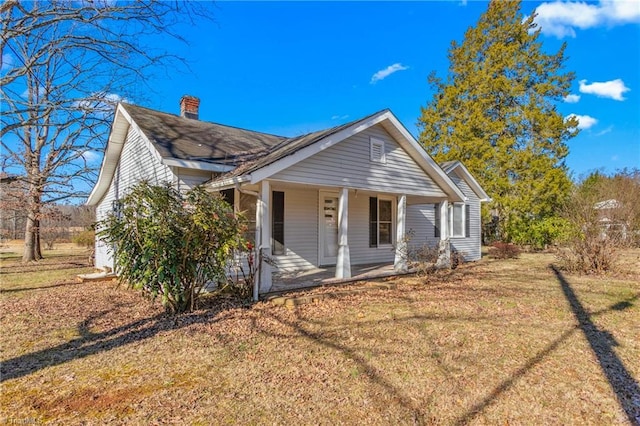 bungalow-style home featuring a front yard and covered porch