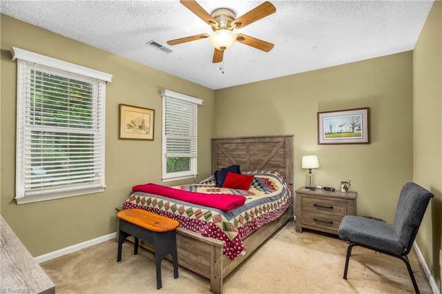 bedroom with visible vents, baseboards, a textured ceiling, a ceiling fan, and carpet