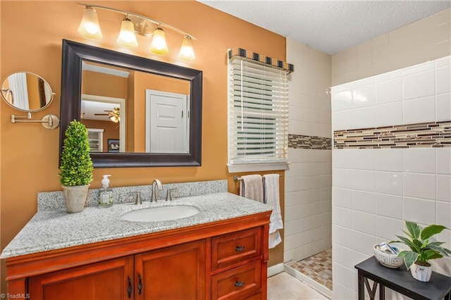 full bathroom with vanity, a textured ceiling, and walk in shower