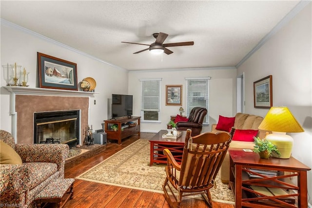 living area with a textured ceiling, ceiling fan, ornamental molding, and hardwood / wood-style flooring