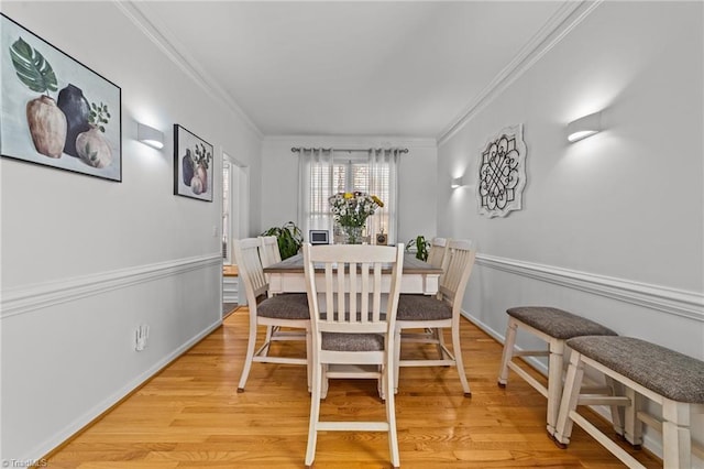 dining area with crown molding, baseboards, and wood finished floors