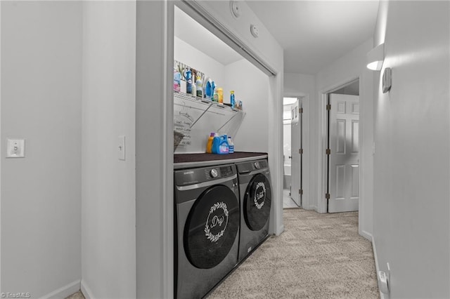 clothes washing area featuring washer and dryer, laundry area, baseboards, and carpet