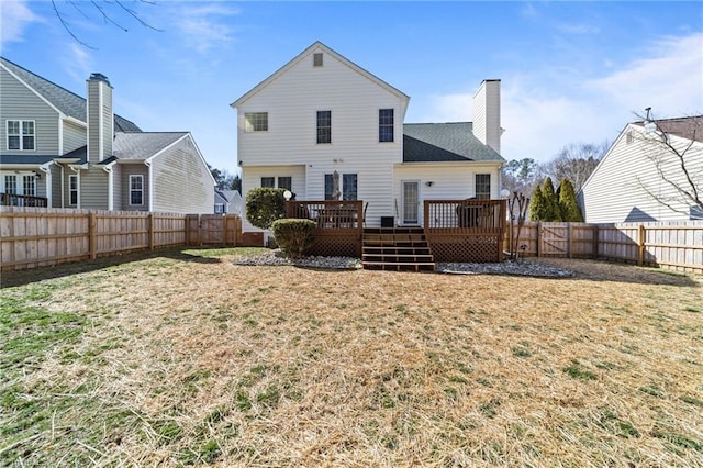 rear view of property with a chimney, a fenced backyard, a yard, and a deck