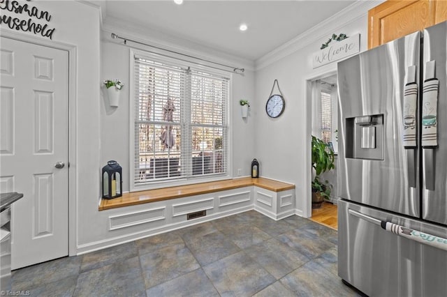 kitchen with crown molding, baseboards, visible vents, and stainless steel fridge with ice dispenser