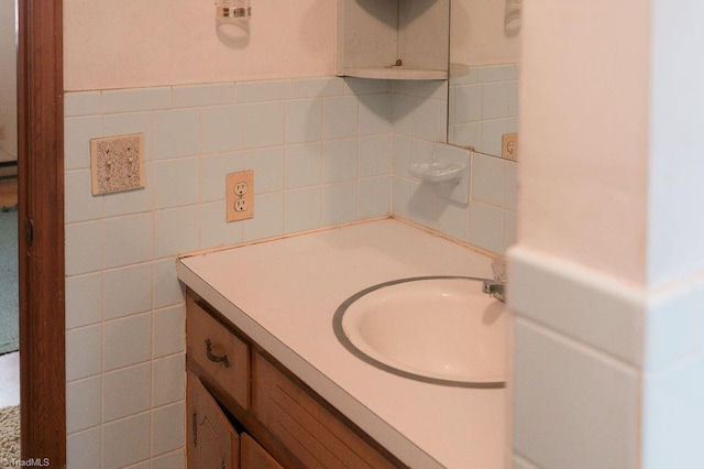 bathroom featuring vanity and tile walls