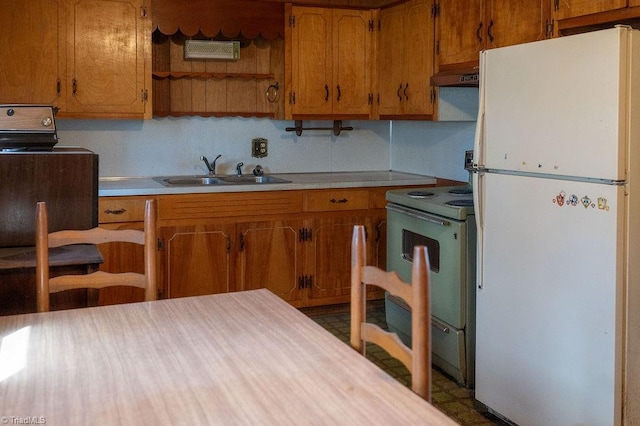 kitchen featuring light countertops, electric range, freestanding refrigerator, a sink, and under cabinet range hood