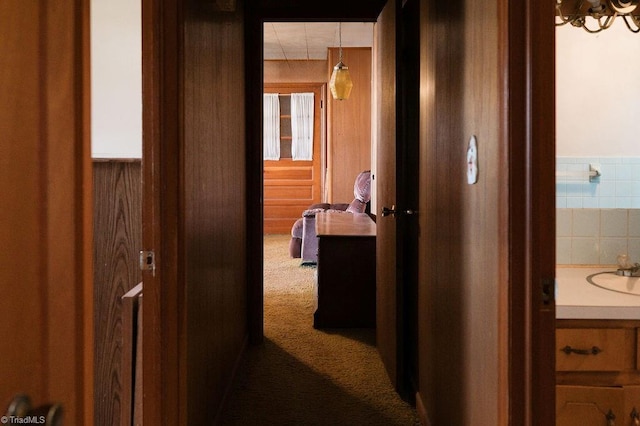 hallway with carpet floors and a sink