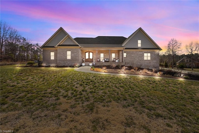 view of front of property with a lawn and brick siding