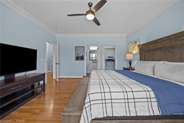 bedroom featuring wood finished floors, baseboards, ceiling fan, ornamental molding, and a spacious closet