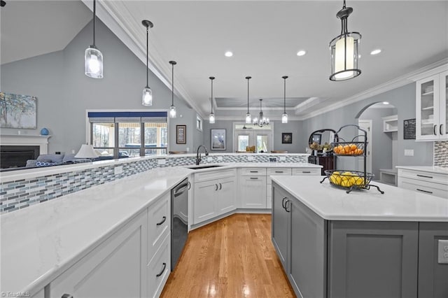 kitchen with dishwasher, tasteful backsplash, open floor plan, and a sink