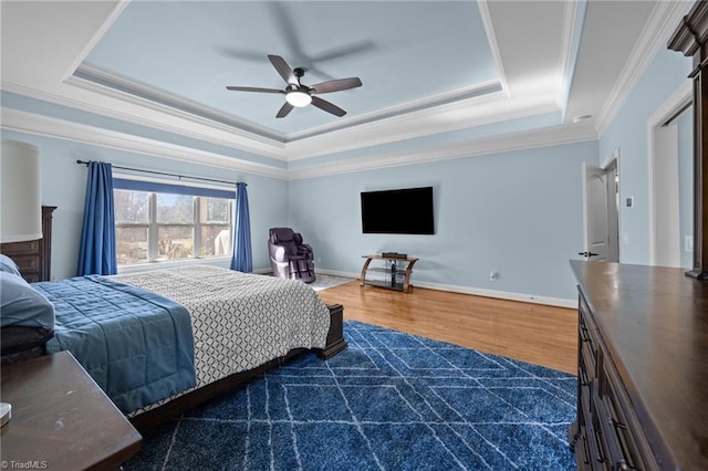 bedroom with a tray ceiling, crown molding, baseboards, and dark wood-style flooring