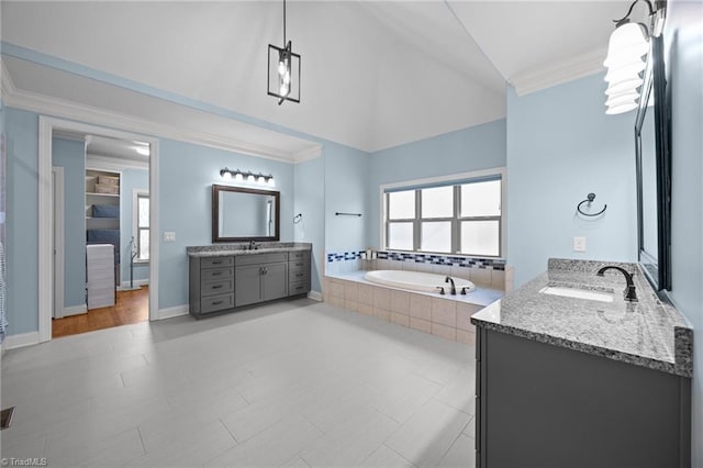 full bath with a garden tub, lofted ceiling, two vanities, a sink, and crown molding