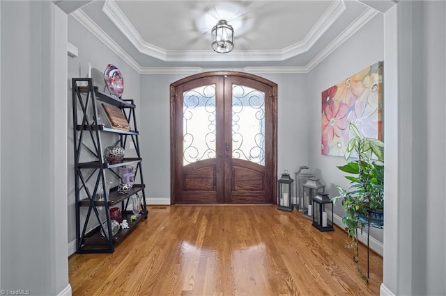 entryway with crown molding, wood finished floors, baseboards, and french doors